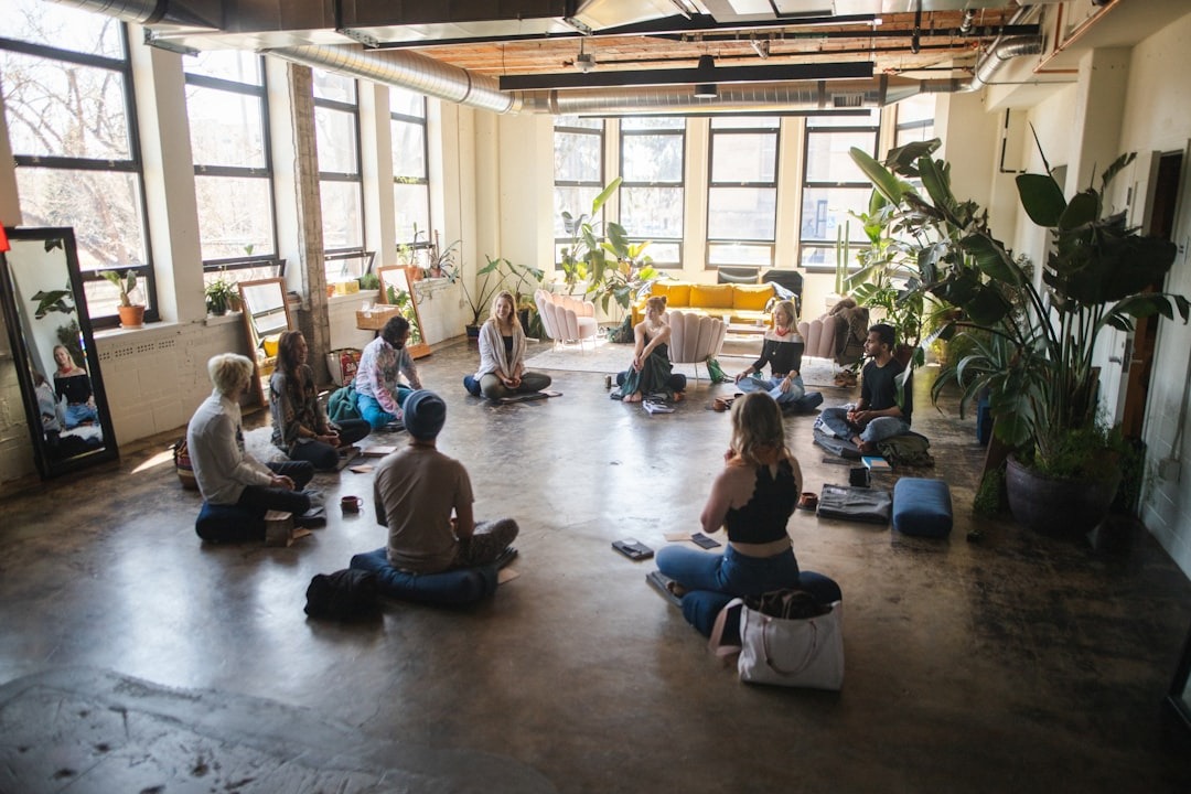 Diverse young adults discussing ideas on a concrete floor workshop space.